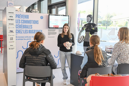 Zoom sur une doctorante présentant sa recherche avec un crâne dans les mains